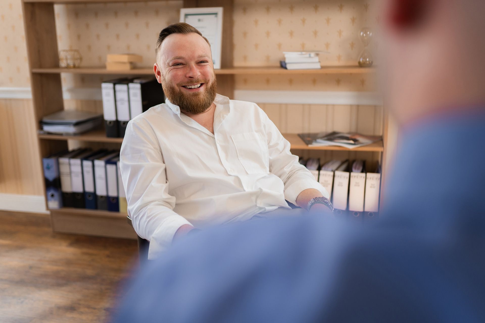 Lächelnder Makler im Gespräch mit einer Person